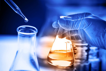 Flask in scientist hand with chemical liquid 