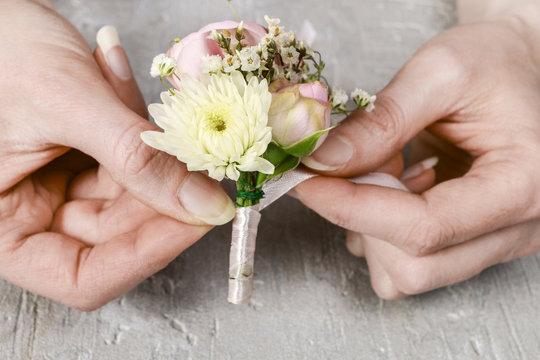 Florist at work. Steps of making wedding boutonniere