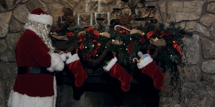 Santa Claus filling stockings hung above a fireplace