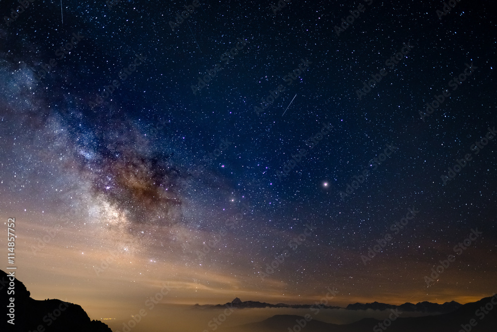 Wall mural the colorful glowing core of the milky way and the starry sky captured at high altitude in summertim