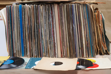 Retro styled image of a collection of old vinyl record lp's with sleeves on a wooden background....