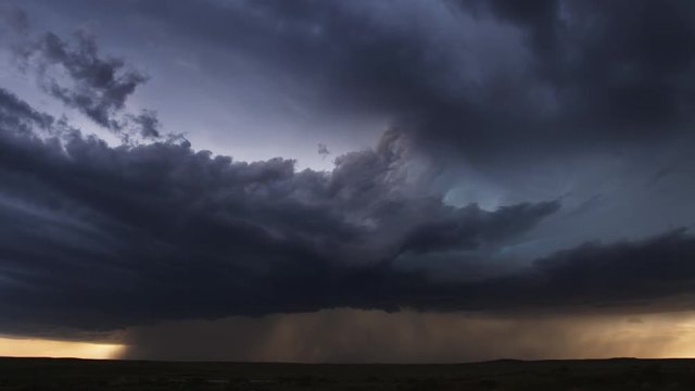 Thunderstorm with pouring rain and multiple lightning flashes over prairie, time lapse