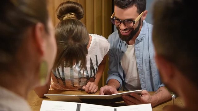 Trendy people in a restaurant looking at menu