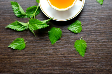 herbal nettle tea in a porcelain Cup on a dark wooden background