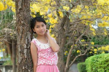 Portrait of asian girl in yellow tabebuia garden at the morning.