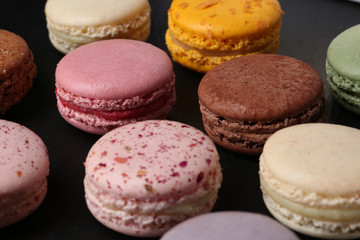 Sweet and colourful french macaroons on black  background