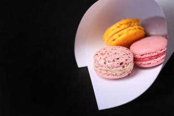 Sweet and colourful french macaroons on black  background