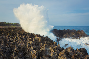 Fototapeta na wymiar Ocean water waves breaks over rocks, Bali, Indonesia