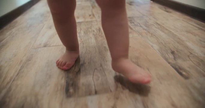 Close-up of baby boy walking his first steps,slow motion
