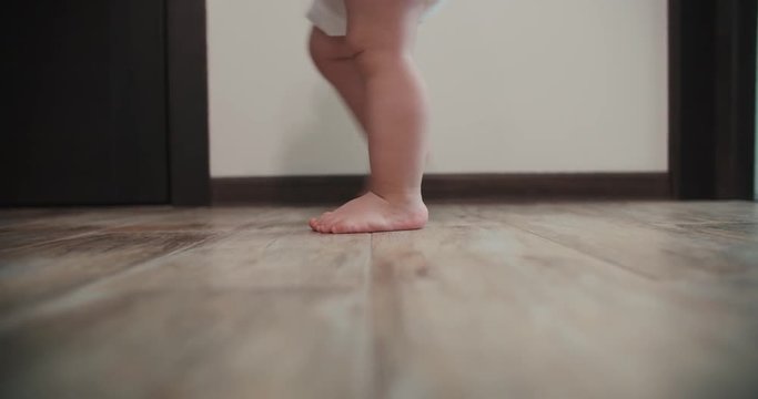 Close-up of baby boy walking his first steps,slow motion