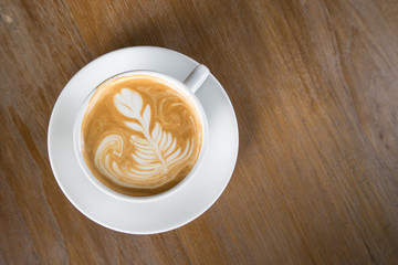 Cup of coffee on a wooden table top view.