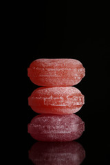 Three red lollipops isolated on black background with reflection