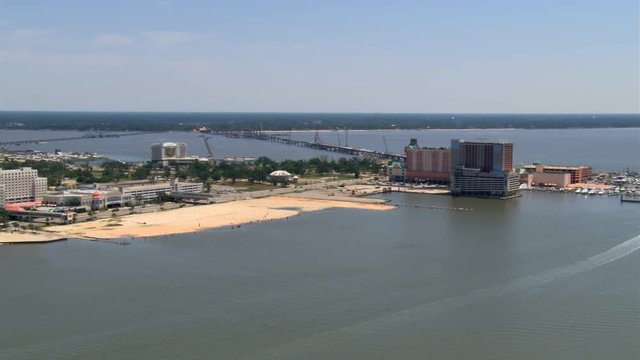 Flight along waterfront past Biloxi, Mississippi, with causeways in background. Shot in 2007.