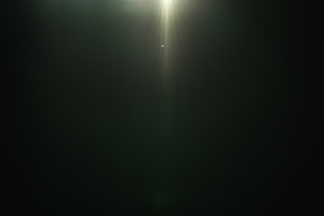 real green lens flare over dark background