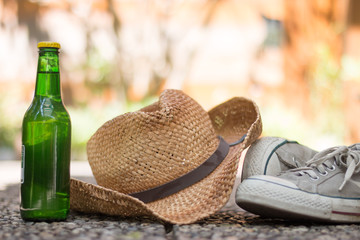 Flasche, Strohhut und Sneakers, Ferien