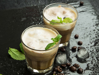 Iced coffee in glasses with ice cubes and fresh mint leaves