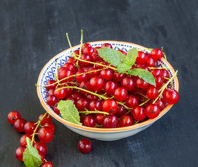 Fresh sweet red currants berries in a bowl with mint