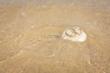Two wedding rings at the beach