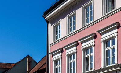 Fototapeta na wymiar Bayrische Altbau - Häuserfassade mit Fenstern in bunten Farben vor Blauem Himmel