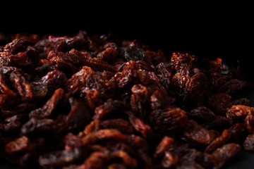 Sultanas / Pile of sultanas on a black plate