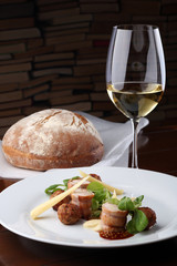 Baked meat rabbit roll and rissole with chees, souses on white plate.