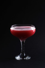Cocktail in a glass goblet on the dark background. Closeup.
