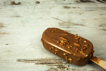 Chocolate ice lolly on a light wooden countertop