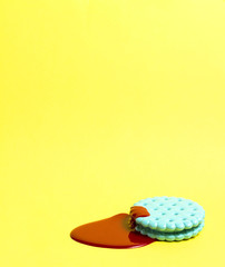 Cracker with paint / Creative photo of mint cracker covered with red paint on yellow background.