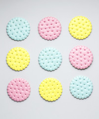 Cookie checks / Creative photo of crackers covered with paint on grey background.