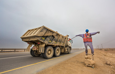 manequin dressed in construction workers safety clothes on the side of a road in Salalah, Oman