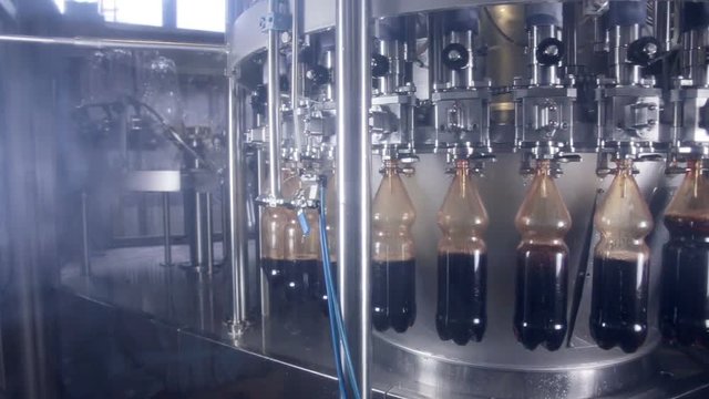 Pop and Soda pouring in bottles on fresh drinks production automated conveyor. 1080p.
