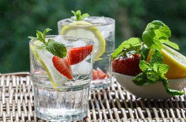 Mineral water with lemon, strawberries and mint. Summer refreshment drink. Detox. Selective focus


