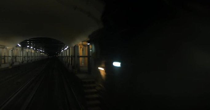 Driveless subway train coming from the tunnel to the station equipped with automatic sliding doors
