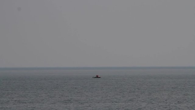 fisherman in an inflatable boat in the early morning on the sea