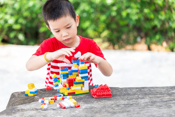 Asian boy build plastic block