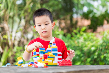 Asian boy build plastic block