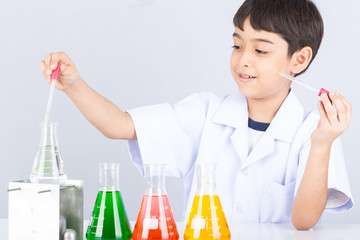 Little scientist boy with colorful flask