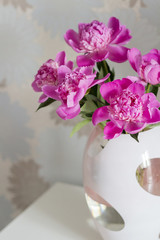 Pink peonies in vase on white background