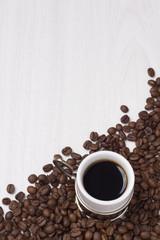 Cup of coffee and coffee beans on white background