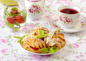 Cream puffs or profiterole filled with whipped cream, powdered sugar topping served with strawberries on the table