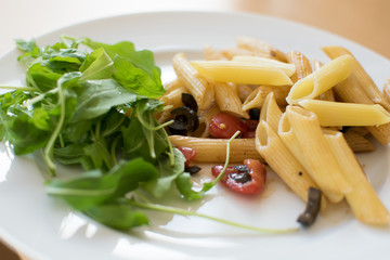 Pasta salad with rocket, tomatoes and olives