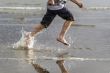 Running on beach making splashes.