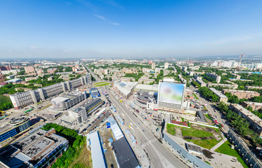 Aerial city view with crossroads and roads, houses, buildings, parks and parking lots, bridges. Copter shot. Panoramic image.