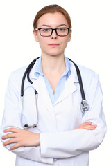 Young brunette female doctor standing with arms crossed. Isolated over white background.