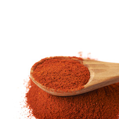 Wooden spoon over the pile of paprika