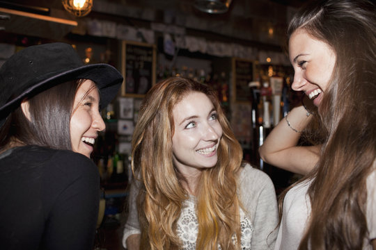 Happy young friends meeting at a bar
