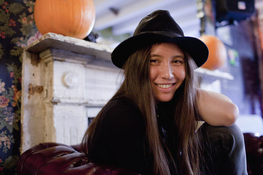 Portrait of smiling young woman sitting on sofa