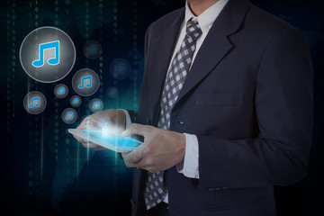 Businessman hand touch music icons on a tablet.