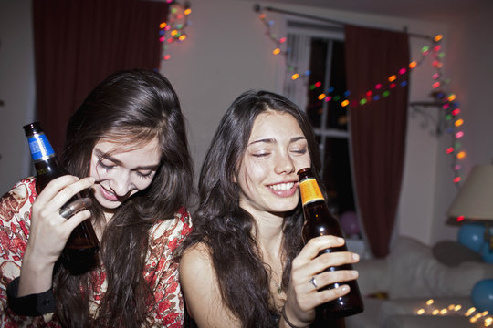 Cheerful female friends drinking at the party