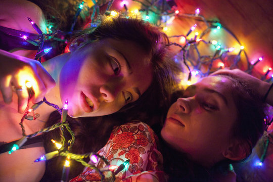Young women illuminated by string lights